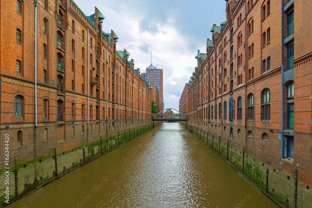 The Speicherstadt is famous landmark of city Hamburg in Germany. It is the largest warehouse district in world. Red brick buildings stand on timber-pile foundations.