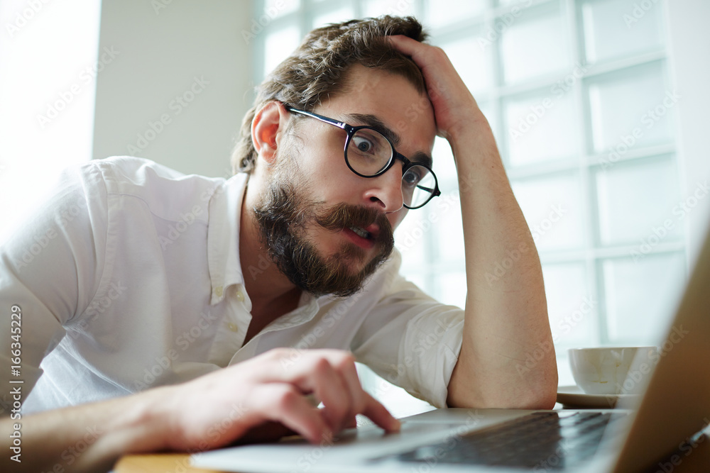 Nervous job-seeker sitting in front of laptop Nervous job-seeker sitting in front of laptop