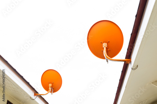 Satellite dish attached to the roof of the houseSatellite dish attached to the roof of the house  isolated on white background. photo