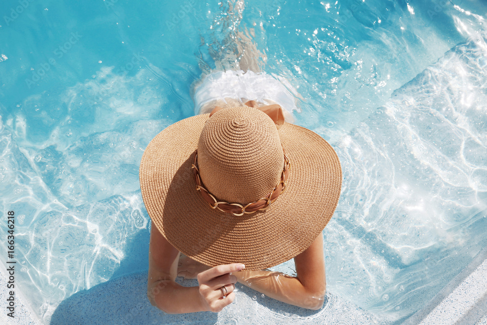 Woman in beach hat enjoying in swimming pool on Tropical Resort. Exotic Paradise. Travel, Tourism and Vacations Concept. - obrazy, fototapety, plakaty 