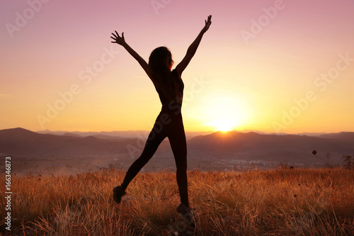Freedom. Free jumping woman with open arms on sunset. success. Travel. Good life. © Victoria Andreas