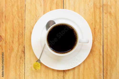 Coffee cup with spoon on wooden table, Top view.