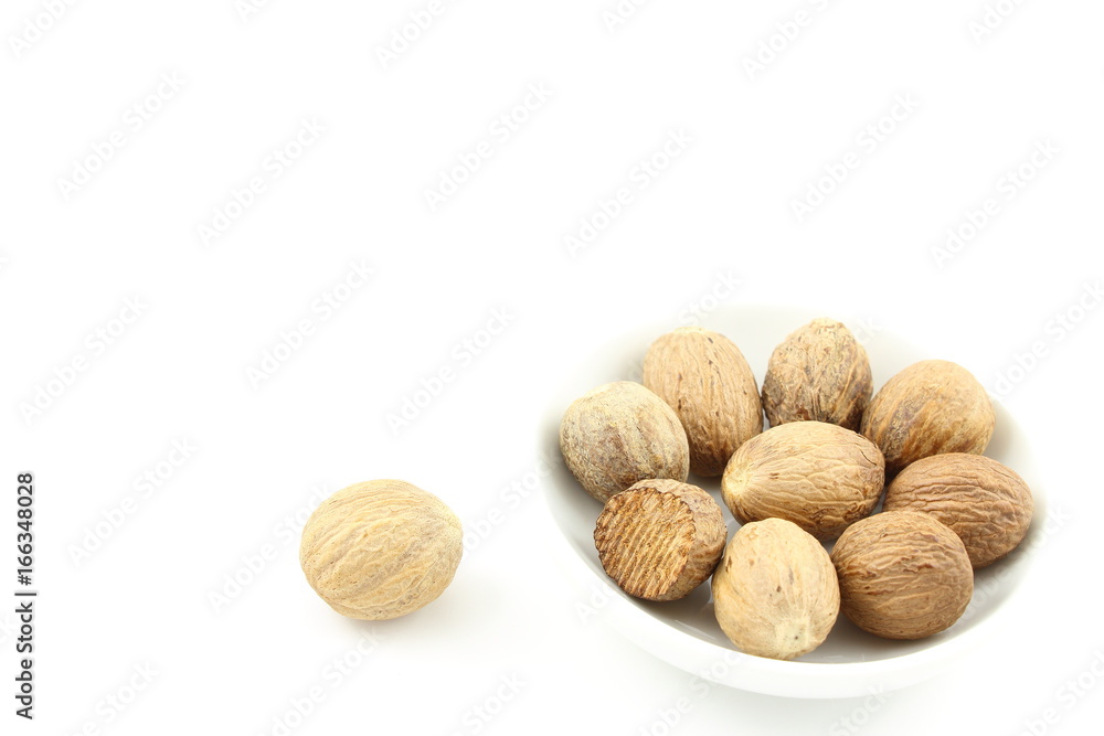 nutmeg seeds in a small white bowl nutmeg seeds in a small white bowl