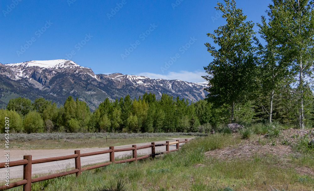 Snowcovered mountainrange landscape with split rail wooden fence 