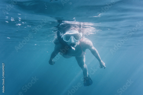 Woman swimming underwater surface.