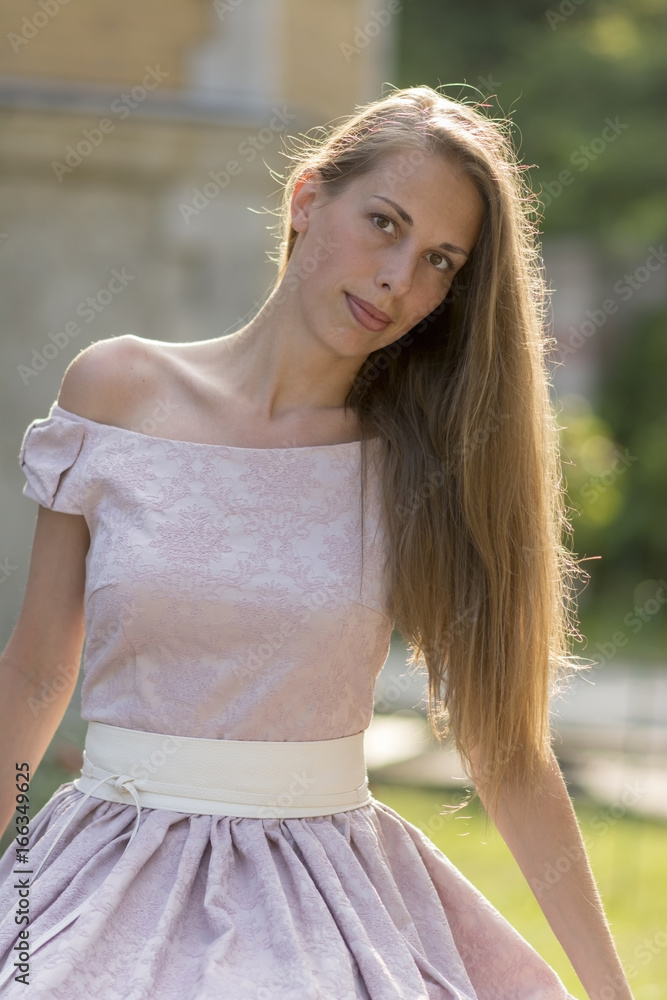 Portrait of a beautiful woman with long hair in a pink dress Portrait of a beautiful woman with long hair in a pink dress