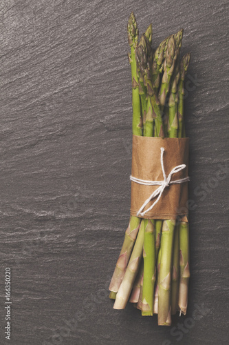 Fresh asparagus tied in a bunch on a rustic slate background