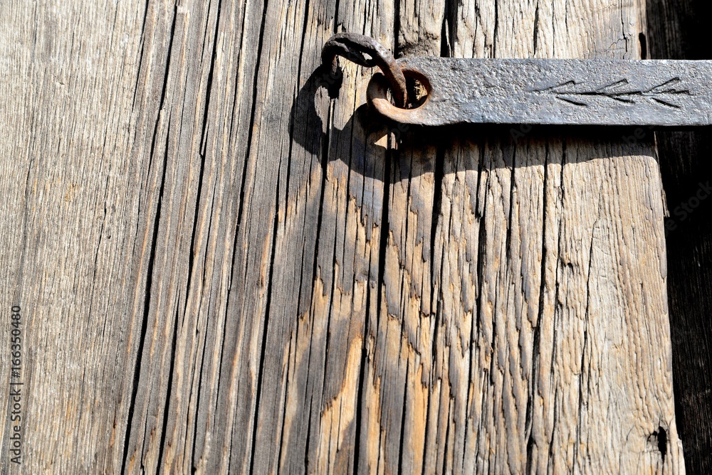 A fragment of an old wooden door closed on a steel skeleton