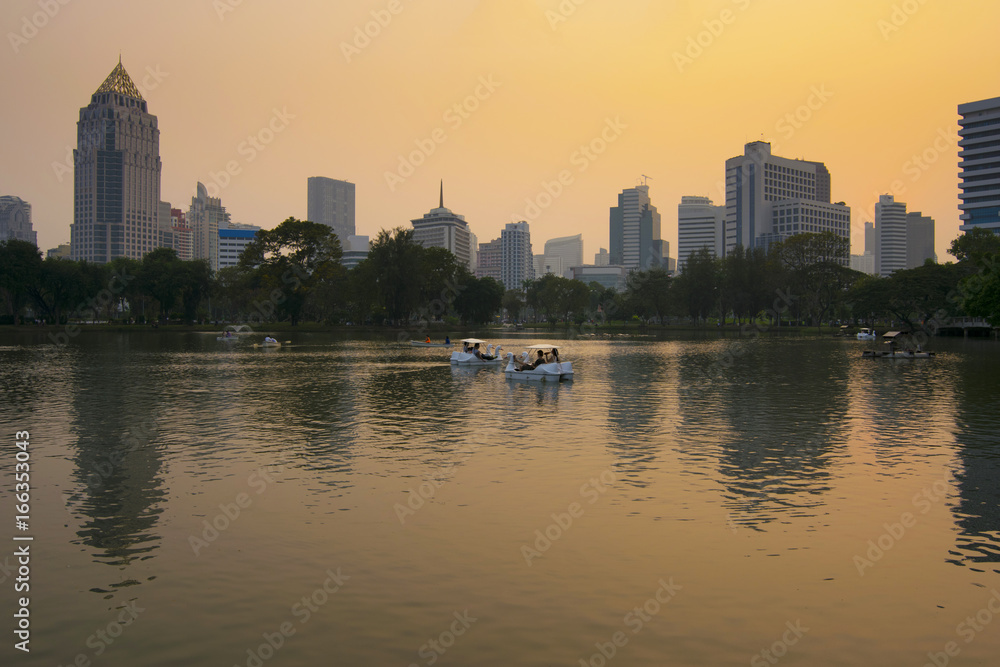 Lumpini park in Bangkok at dusk with tourists are enjoy driving duck boat.
