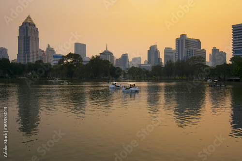 Lumpini park in Bangkok at dusk with tourists are enjoy driving duck boat.