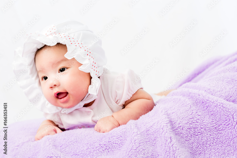 Portrait of a little adorable infant baby girl lying on the tummy on the pillow with head band Portrait of a little adorable infant baby girl lying on the tummy on the pillow with head band