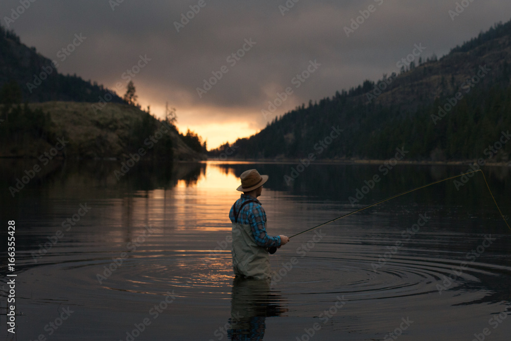Fishing by a lake at sunset Fishing by a lake at sunset