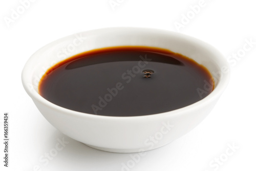 Soya sauce in white ceramic bowl isolated on white.