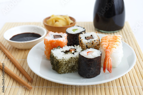 Fotografia Selection of sushi on bamboo mat with chopsticks, soya sauce and pickled ginger