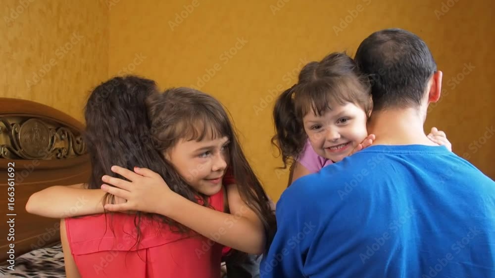 Children hug their parents. Little girls hug mom and dad. Children hug their parents. Little girls hug mom and dad.