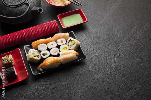 Quadro em tela Sushi set and black teapot on black table