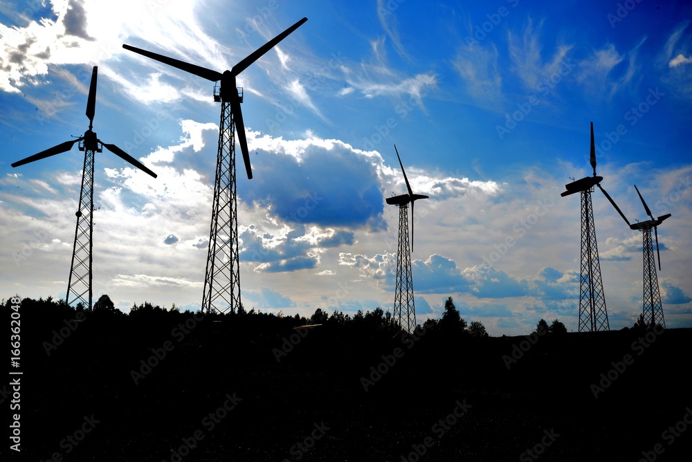 A wind farm or windmills producing energy against the sky