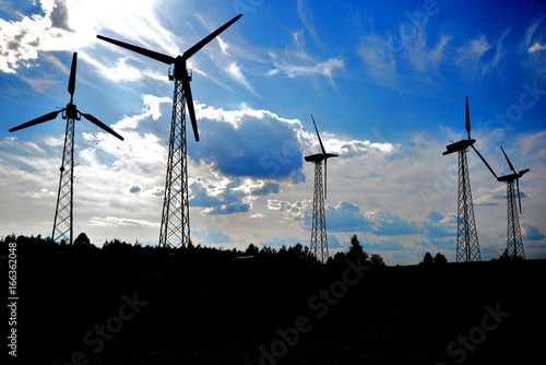 A wind farm or windmills producing energy against the sky