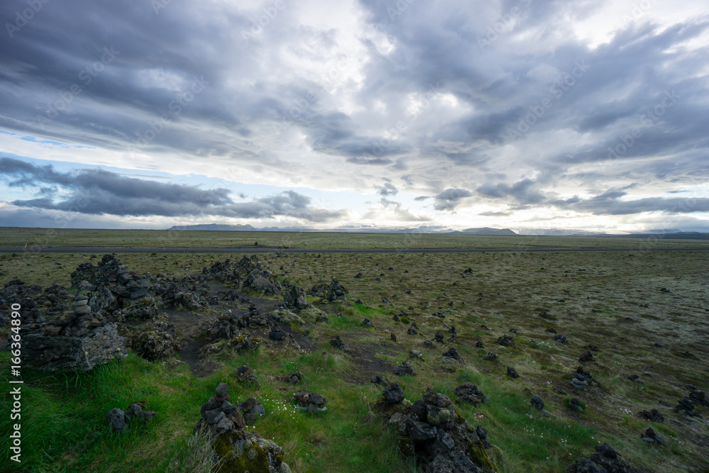 Iceland - Green lowlands and far mountains at dawn with clouds