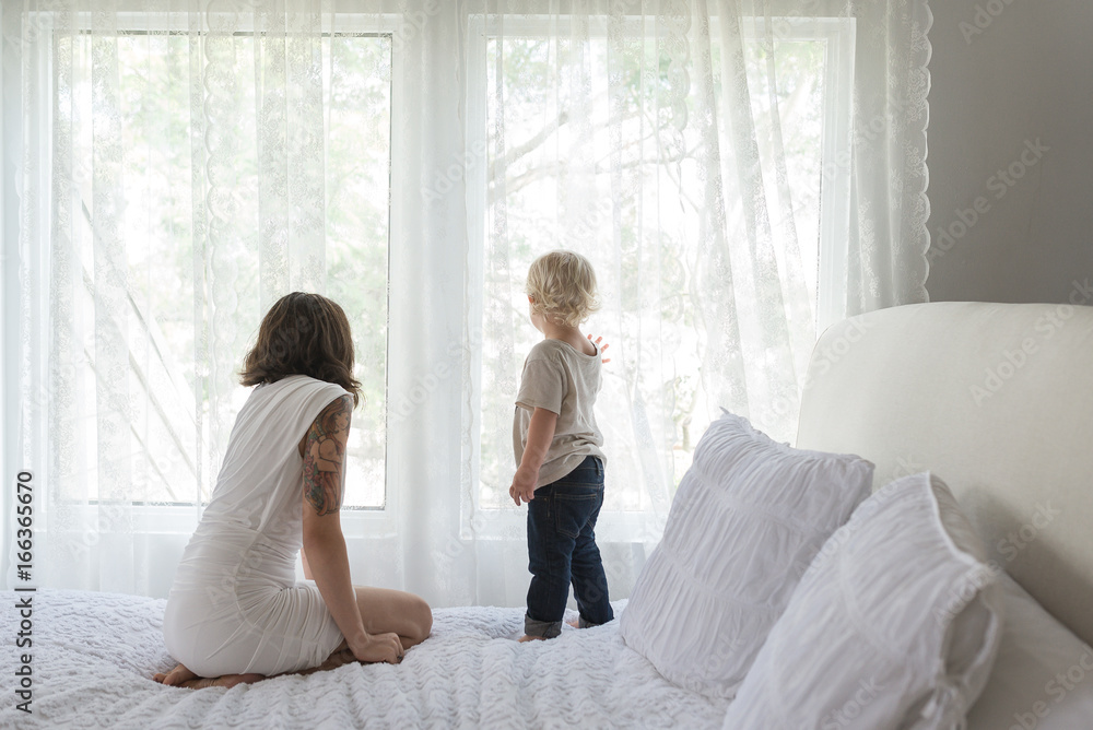 Mother Watches Son As He Looks Out The Window Mother Watches Son As He Looks Out The Window
