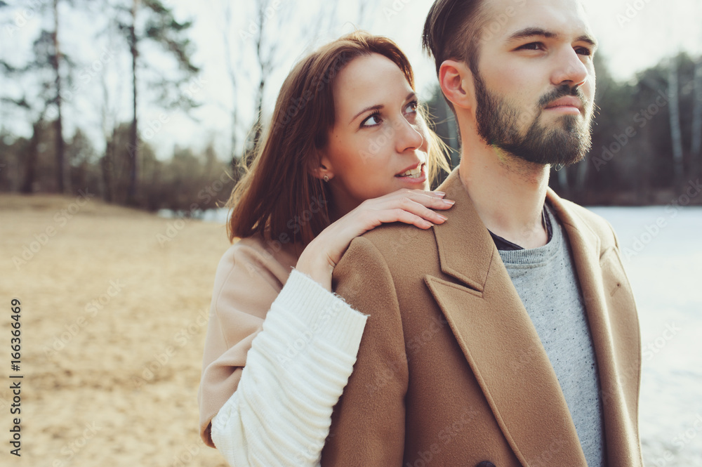 Naklejka premium young happy loving couple walking outdoor in autumn or early spring