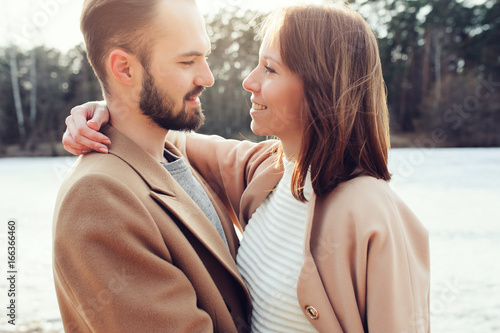 young happy loving couple walking outdoor in autumn or early spring