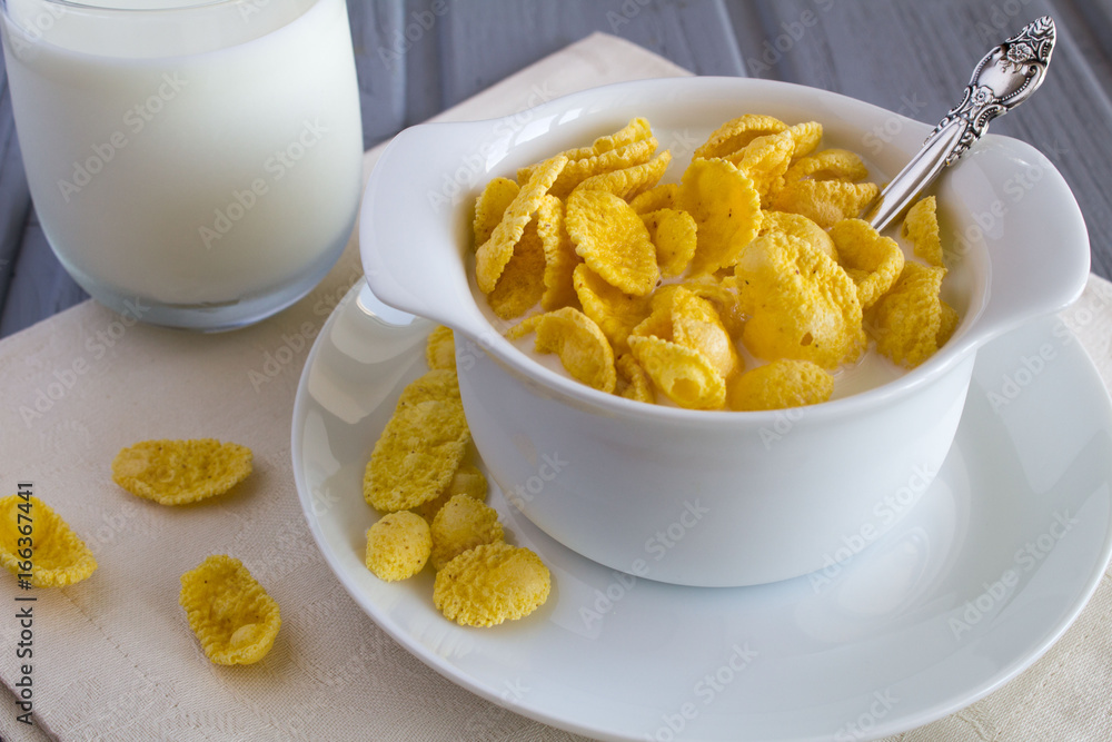 Healthy breakfast with corn flakes and milk in the white plate Healthy breakfast with corn flakes and milk in the white plate
