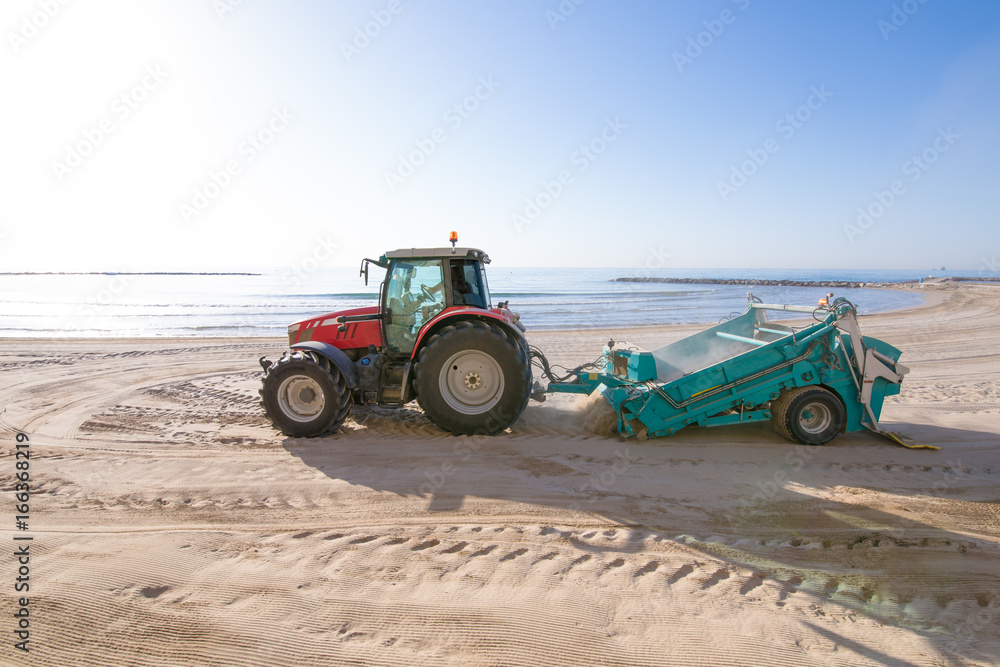 red tractor with trailer cleaner cleaning sand in Els Terrers Beach, Benicassim, Castellon, Valencia, Spain, Europe. Mediterranean Sea
red tractor with trailer cleaner cleaning sand in Els Terrers Beach, Benicassim, Castellon, Valencia, Spain, Europe. Mediterranean Sea