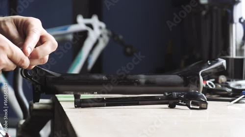 Man puts the bicycle parts on the table photo