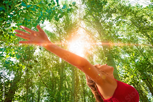 Fotografie Mujer con los brazos abiertos en paisaje con arboles
