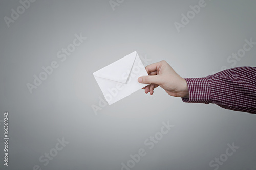 Businessman`s hand with envelope on dark background