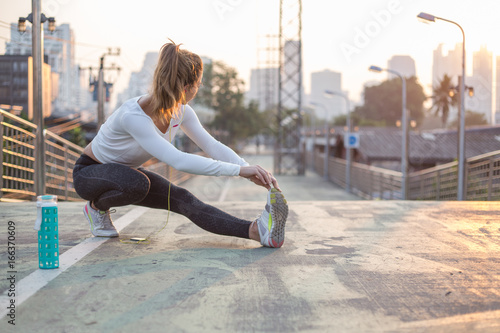 sport, fitness, exercise and lifestyle concept - woman stretching outdoors