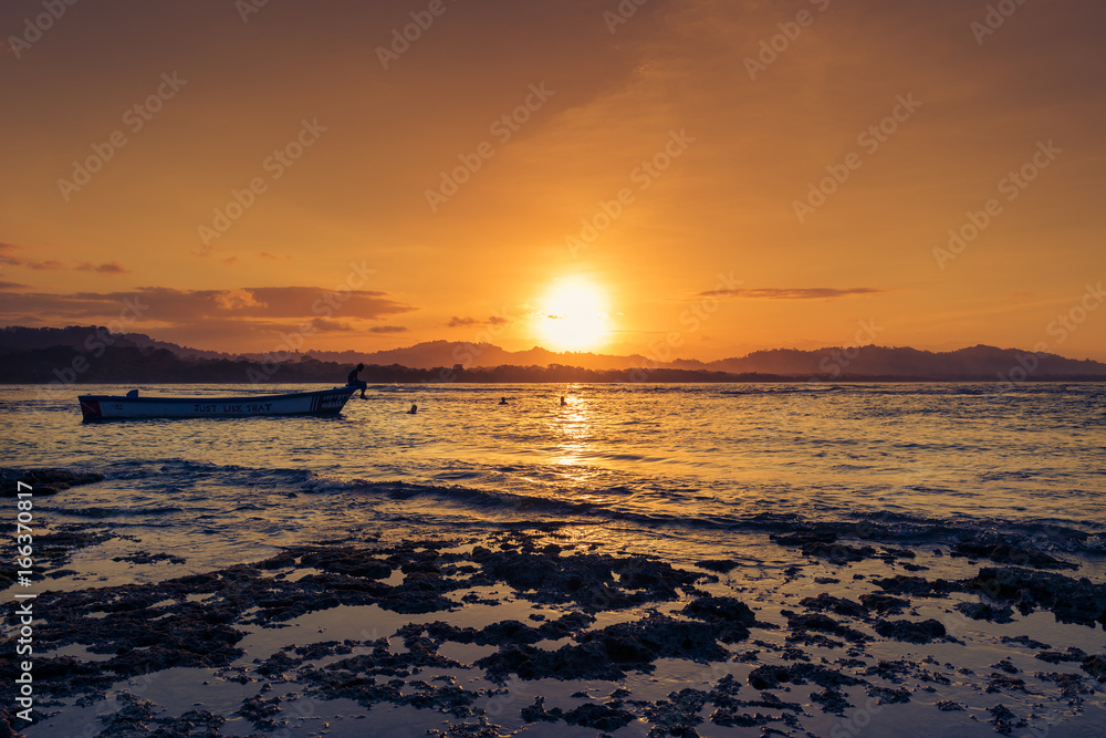 People swimming at the beach in Puerto Viejo de Talamanca, Costa Rica, at sunset