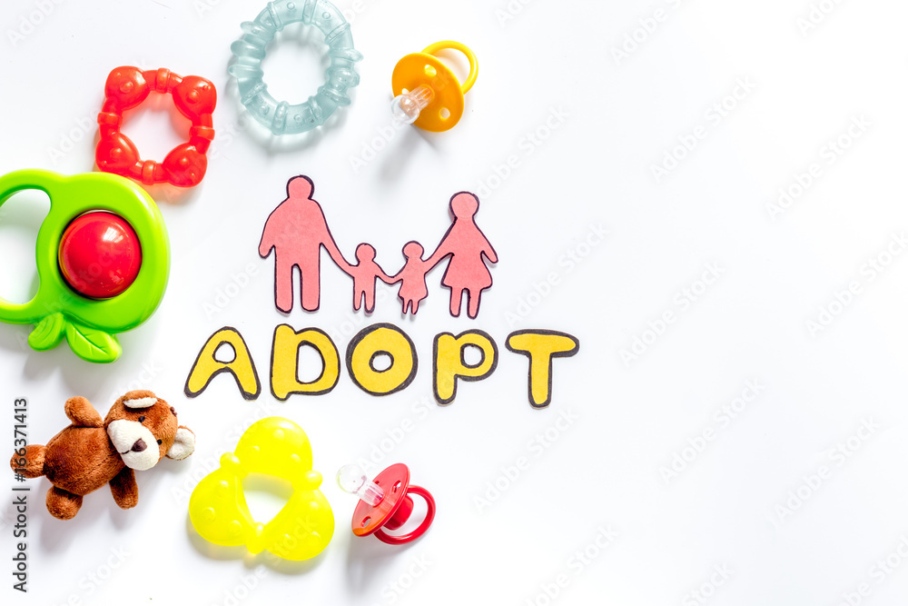 Adopt word, paper silhouette of family and toys on white background top view copyspace Adopt word, paper silhouette of family and toys on white background top view copyspace