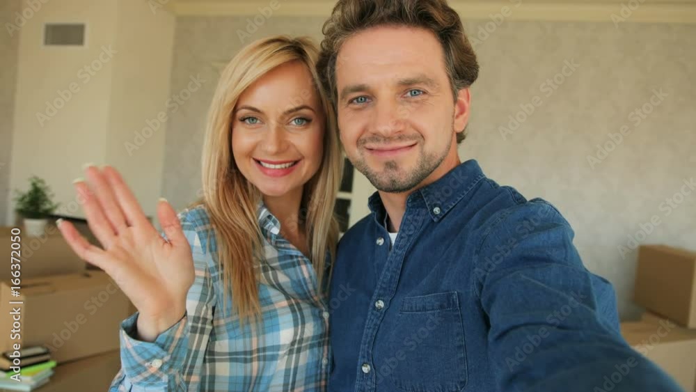 Attractive couple making selfie on camera in new apartment after moving in. Close up shot. Attractive couple making selfie on camera in new apartment after moving in. Close up shot.