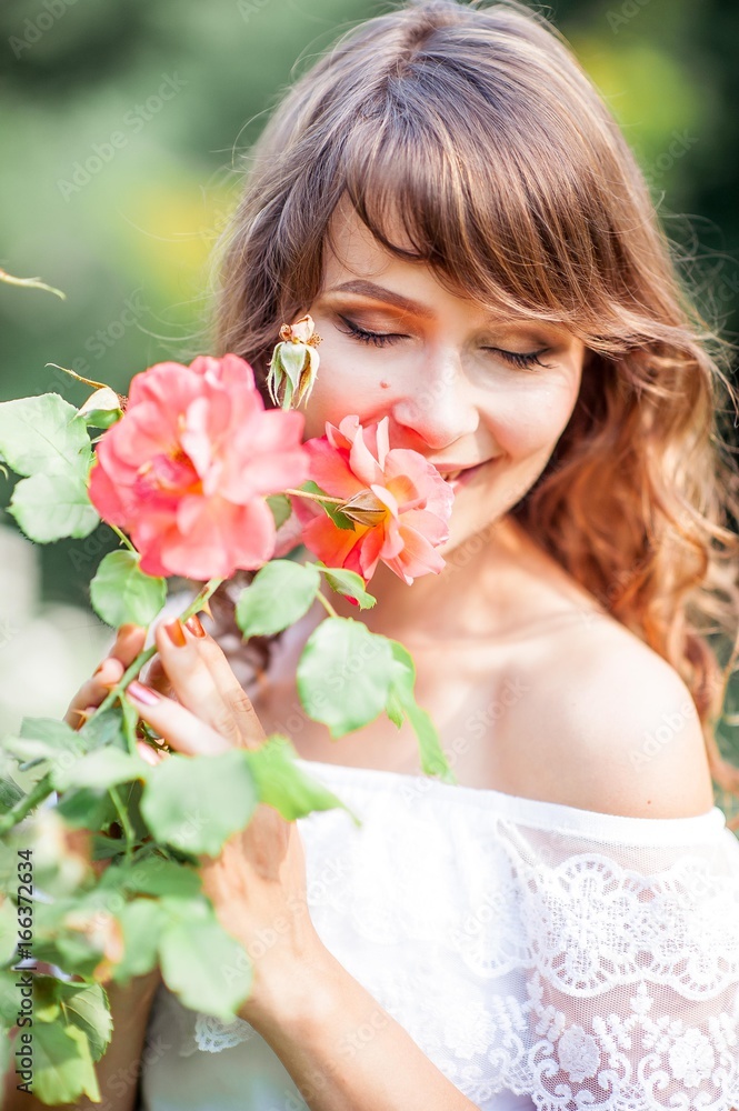 Fototapeta premium Young beautiful woman walks in flowery Park. Portrait of a young woman. Happy girl. Summer.