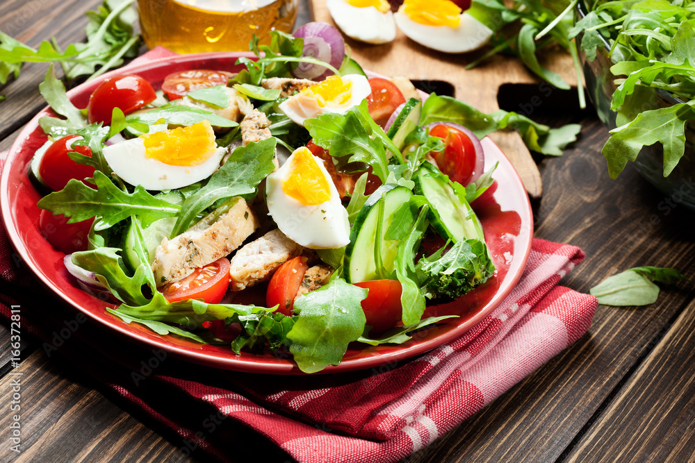 Fresh salad with chicken, tomatoes, eggs and arugula on plate Fresh salad with chicken, tomatoes, eggs and arugula on plate