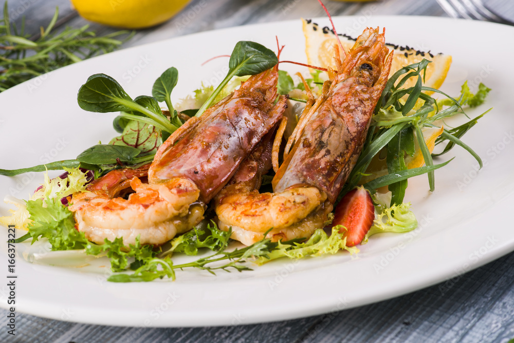  Fried shrimp with salad on a wooden background