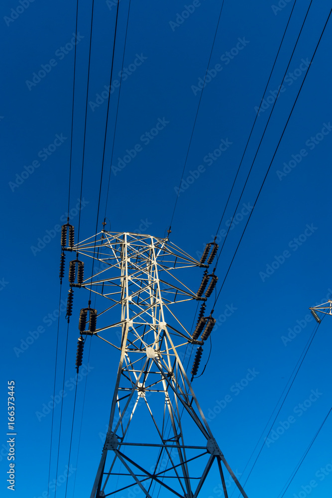 Electricity pylon silhouetted against blue sky background. High voltage tower Electricity pylon silhouetted against blue sky background. High voltage tower