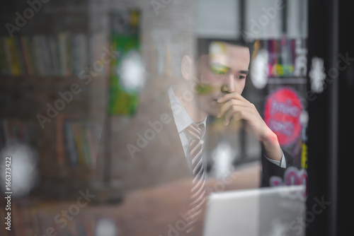 Portrait of an upset businessman at desk in office. Businessman being depressed by working in office. Young stressed business man feeling strain in eyes after working for long hours on compute