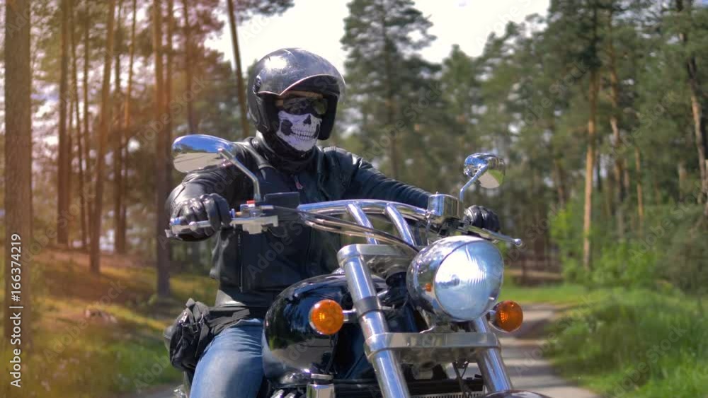Portrait. A man in a skull mask sits on a bike. Portrait. A man in a skull mask sits on a bike.