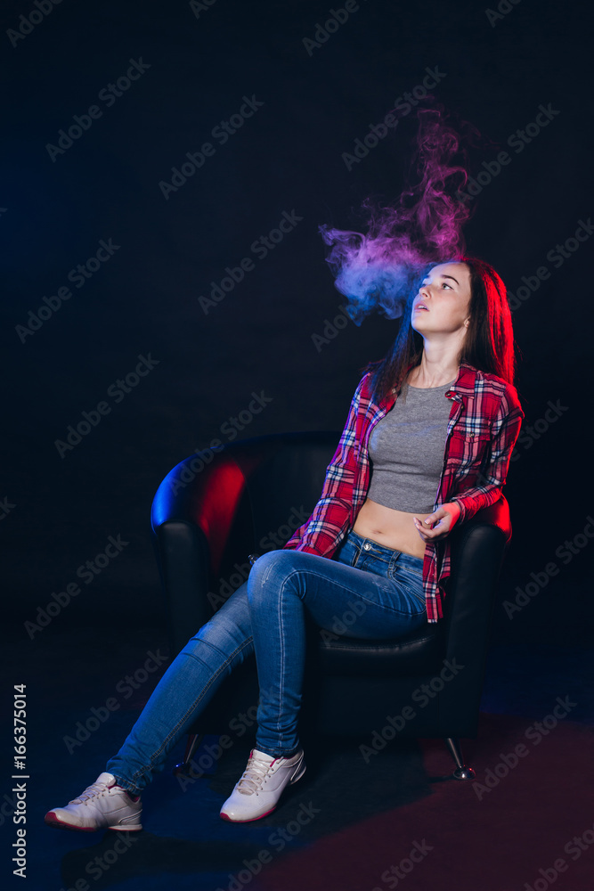 Fototapeta premium Woman smoking electronic cigarette with smoke