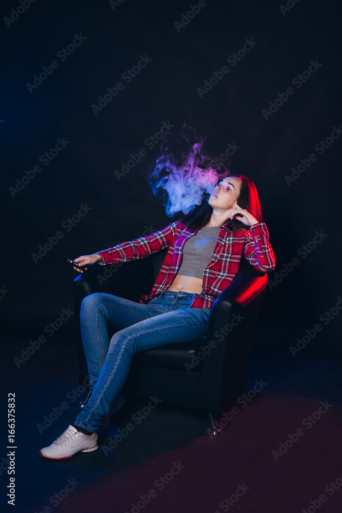Fototapeta premium Woman smoking electronic cigarette with smoke