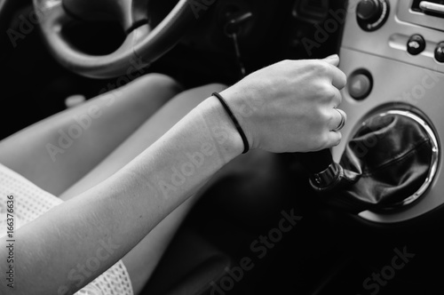 Close-up of a female hand in a modern car over interior background