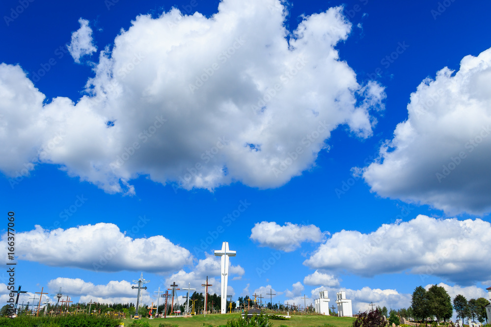 Catholic crosses on the hill of the Sanctuary of Holy Water beneath the white clouds on the sky, near Bialystok, eastern Poland, Podlasie
