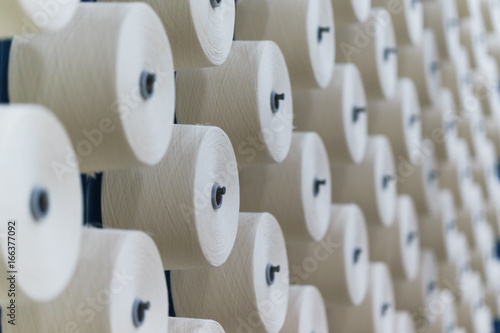 large group of bobbin thread cones on a warping machine in a textile mill.