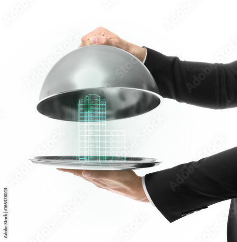 Hands of waiter holding metal tray with cover on white background