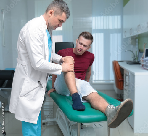 Orthopedist examining patient in clinic photo