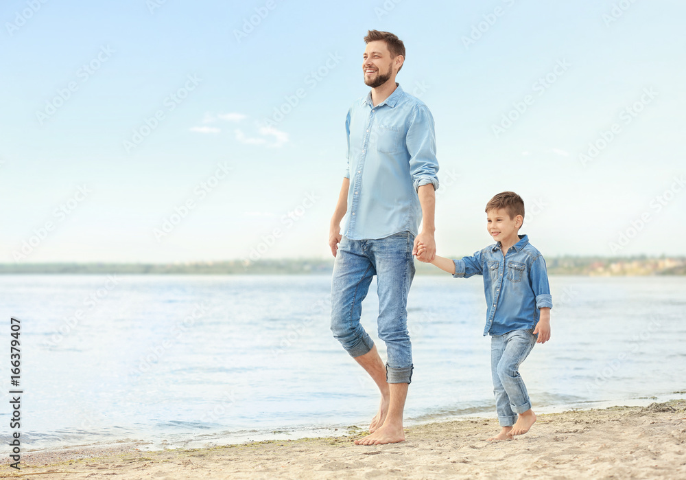 Dad and son walking together on beach