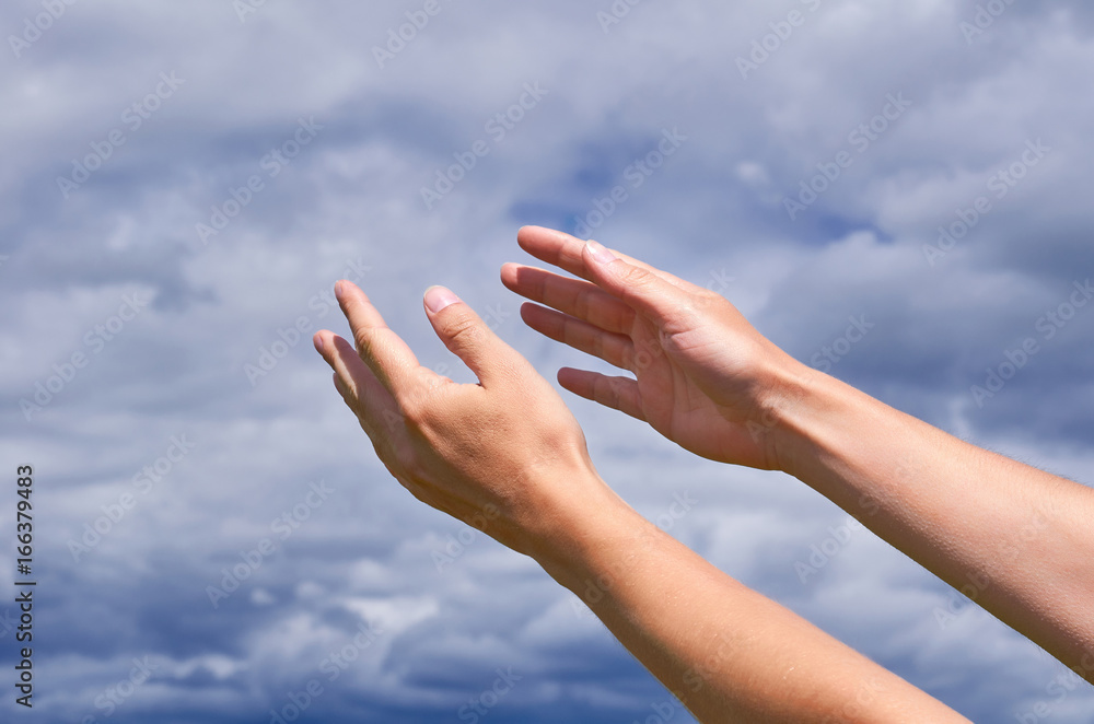 Girl reaches out his hands to the sky, thanks or asking for help. The concept of religion and spirituality, prayer and blessings Girl reaches out his hands to the sky, thanks or asking for help. The concept of religion and spirituality, prayer and blessings